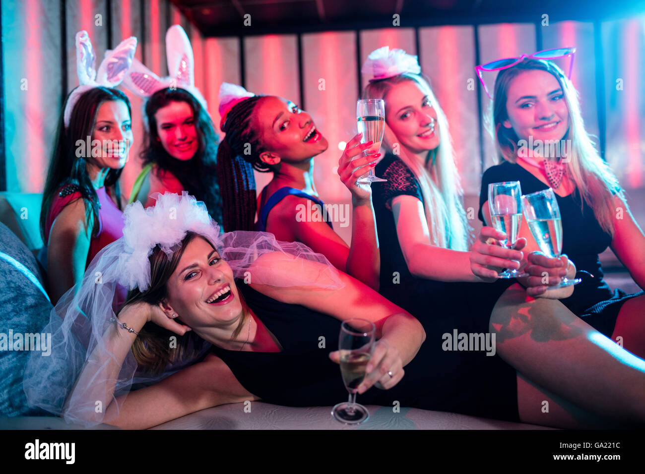 Il gruppo di donne in posa con un bicchiere di champagne Foto Stock