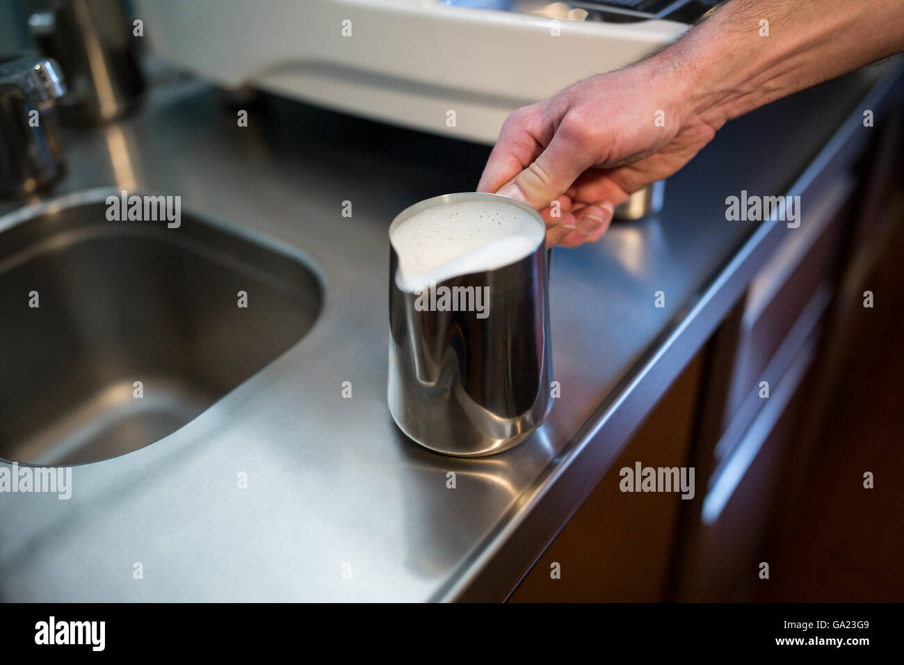 Cameriere azienda brocca del latte Foto Stock