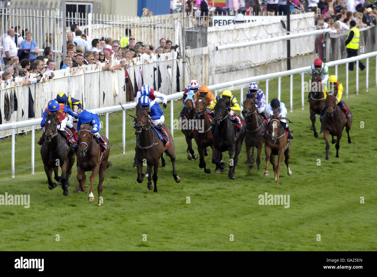 Lago poeta guidato da jockey Seb Sanders conduce il campo nel Vodafone Rose Bowl Heritage handicap presso Epsom Downs Racecourse, Surrey Foto Stock