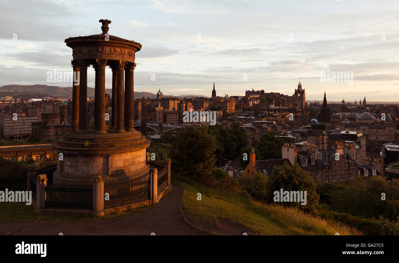 Calton Hill monumento con il Castello di Edinburgo e la città in background al tramonto Foto Stock