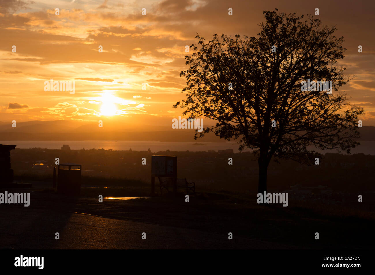 Tramonto da Calton Hill in Edinburgo con ree e panca in contorno Foto Stock