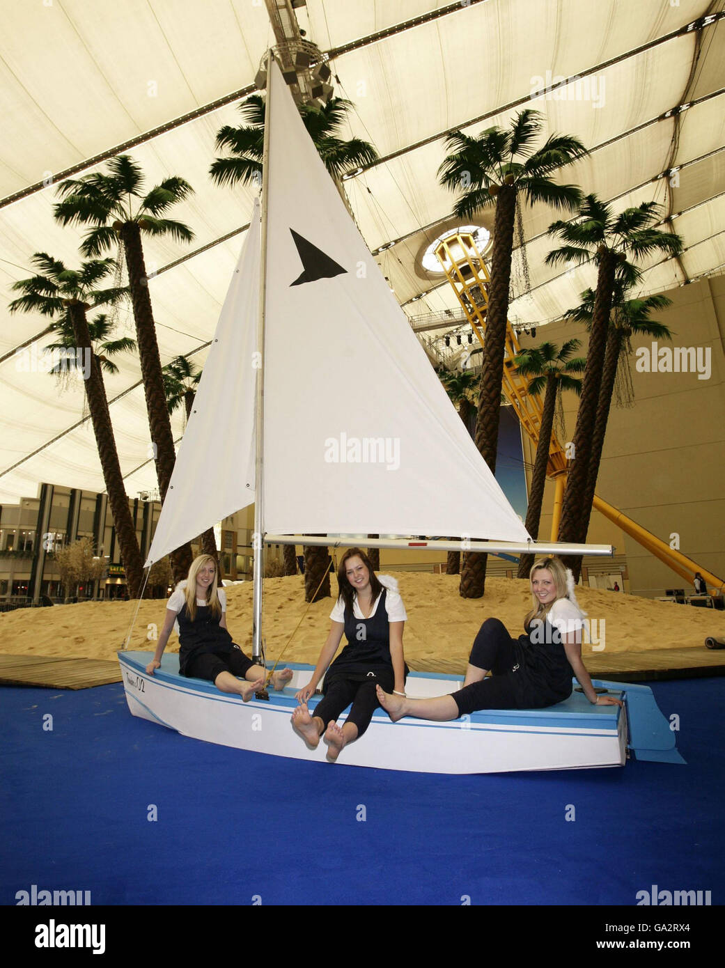 'O2 Angels' (sinistra-destra) Katie Booth, Sadie Irven e Sarah Page Rilassati sulla spiaggia presso l'O2 - una spiaggia al coperto presso il luogo che fornirà proiezioni di film, musica dal vivo ed eventi sportivi dal 12 luglio al 27 agosto - presso l'O2 a Greenwich, a sud-est di Londra. Foto Stock