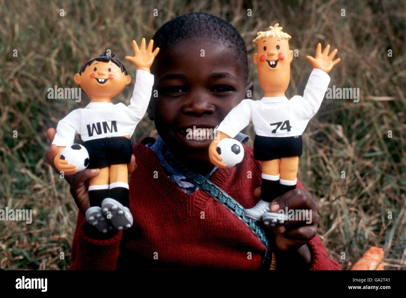 Un ragazzino tiene in mano le mascotte ufficiali per la Coppa del mondo 1974, Tip and Tap Foto Stock