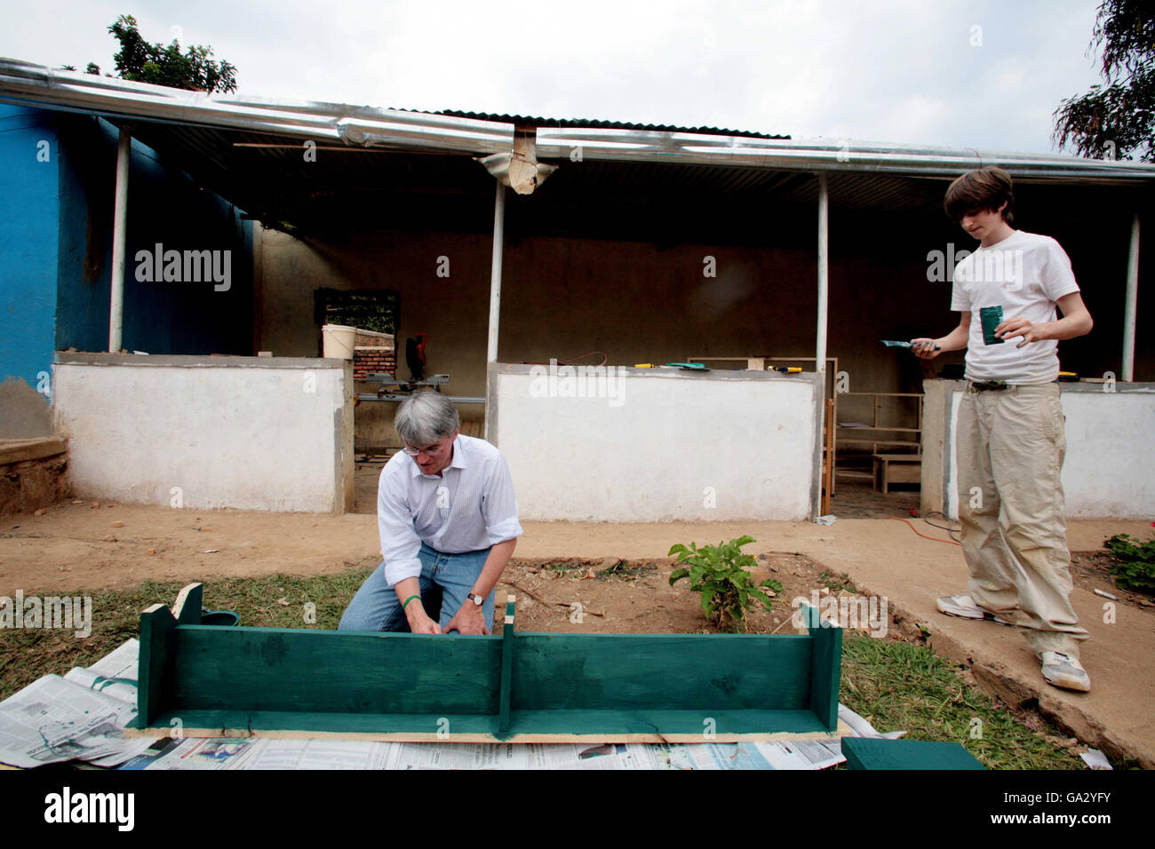 Andrew Mitchell, segretario ombra per lo sviluppo internazionale, e un giovane conservatore (nome non noto) posti a sedere vernice al progetto Girubuntu, che è una scuola e un orfanotrofio nella città di Kigali, Ruanda . Foto Stock