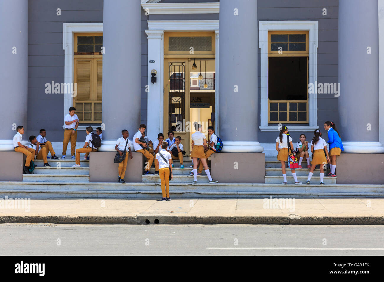 La scuola dei bambini in uniforme di attendere al di fuori della loro scuola a Cienfuegos, sulla costa meridionale di Cuba Foto Stock
