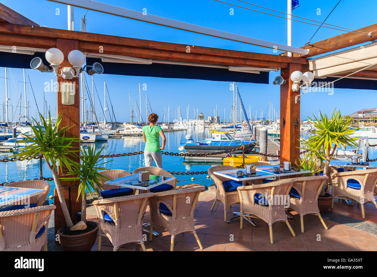 MARINA RUBICON, Lanzarote Island - Jan 17, 2015: il giovane turista in piedi in ristorante nel Rubicone yacht port. Lanzarote è meta di vacanze grazie al soleggiato clima tropicale. Foto Stock