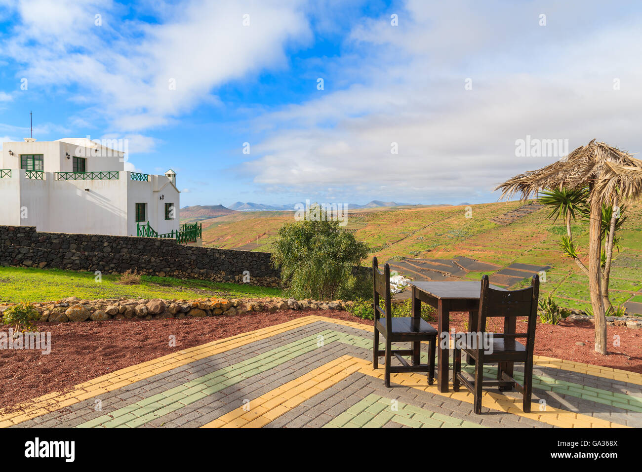 Tavolo con sedie a sdraio sulla terrazza nel paesaggio tropicale dell'isola di Lanzarote a Mirador de Los Valles, Spagna Foto Stock