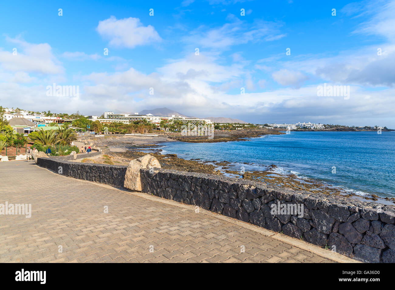 Passeggiata lungo la costa dell'oceano in Playa Blanca holiday resort, Lanzarote, Isole Canarie, Spagna Foto Stock