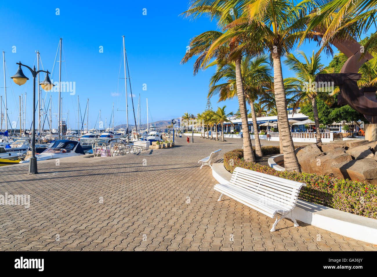 Panca sulla passeggiata costiera in Puerto Calero marina, Lanzarote, Isole Canarie, Spagna Foto Stock
