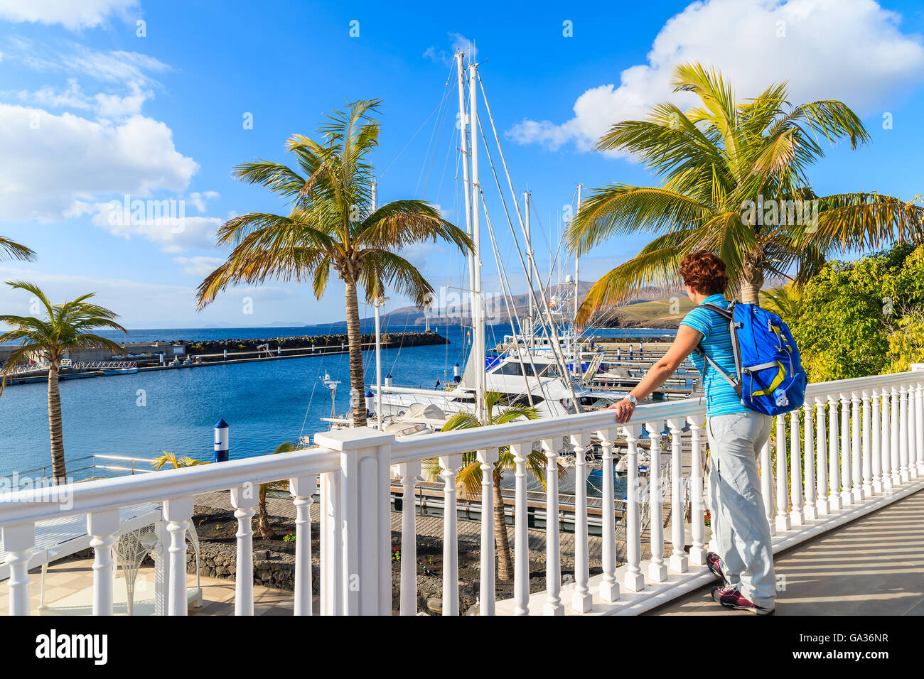 Giovane donna per turisti in cerca di Puerto Calero marina costruito in stile caraibico, Lanzarote, Isole Canarie, Spagna Foto Stock