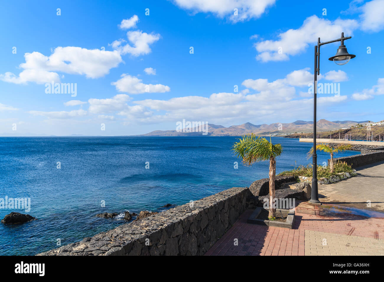 Passeggiata lungo la costa dell'oceano in Puerto del Carmen città di vacanze, Lanzarote, Isole Canarie, Spagna Foto Stock