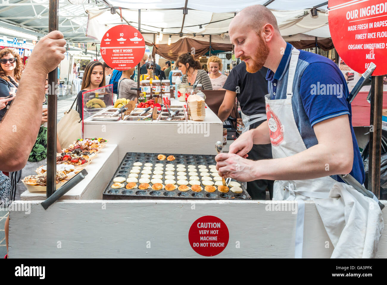 London, Regno Unito - 25 Giugno 2016: mercato di Greenwich. Commerciante di mercato sta facendo mini pancake Foto Stock
