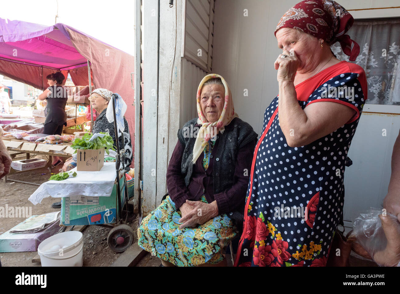 Antica russa nonna Babushka seduto e vendere il suo produrre Foto Stock