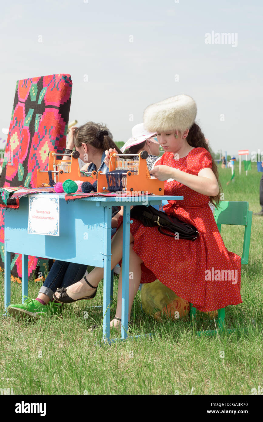 Bambini russi tessitura di tappeti di lana e di materiale per un esterno evento craft Foto Stock