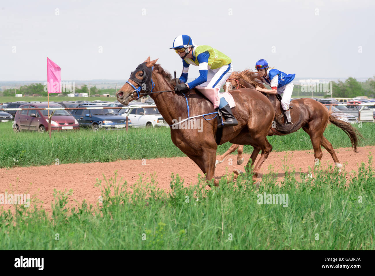 Al galoppo i cavalli e i loro cavalieri a horse racing event in estate Foto Stock