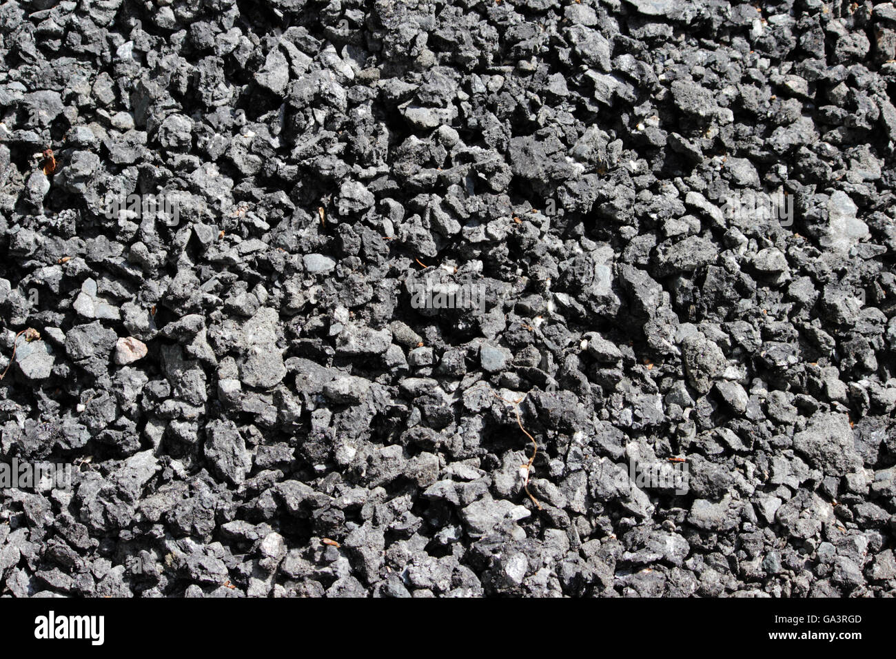 A grana grossa consistenza di un nero argenteo materiale abrasivo da asfalto pietre per carta da parati e per gli sfondi astratti Foto Stock