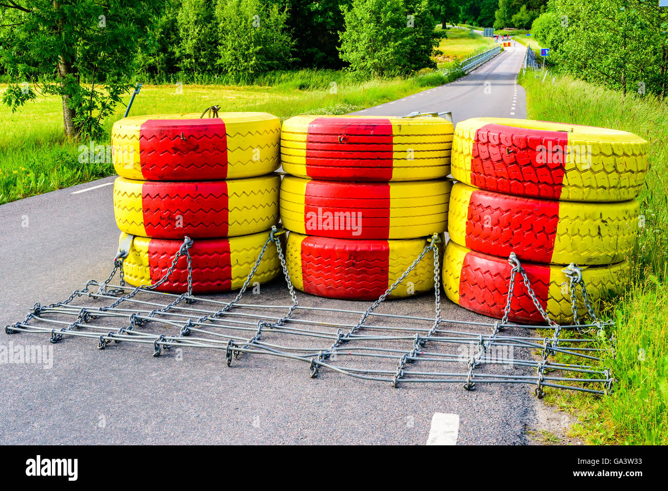 Diga fatta di giallo e rosso dipinto di pneumatici per auto. Ponte dietro è ottenere nuove ringhiere per maggiore sicurezza. Foto Stock