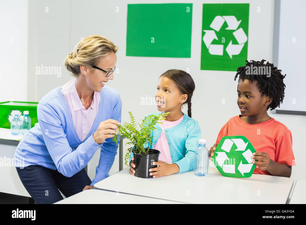 Insegnanti e bambini discutere di riciclare Foto Stock