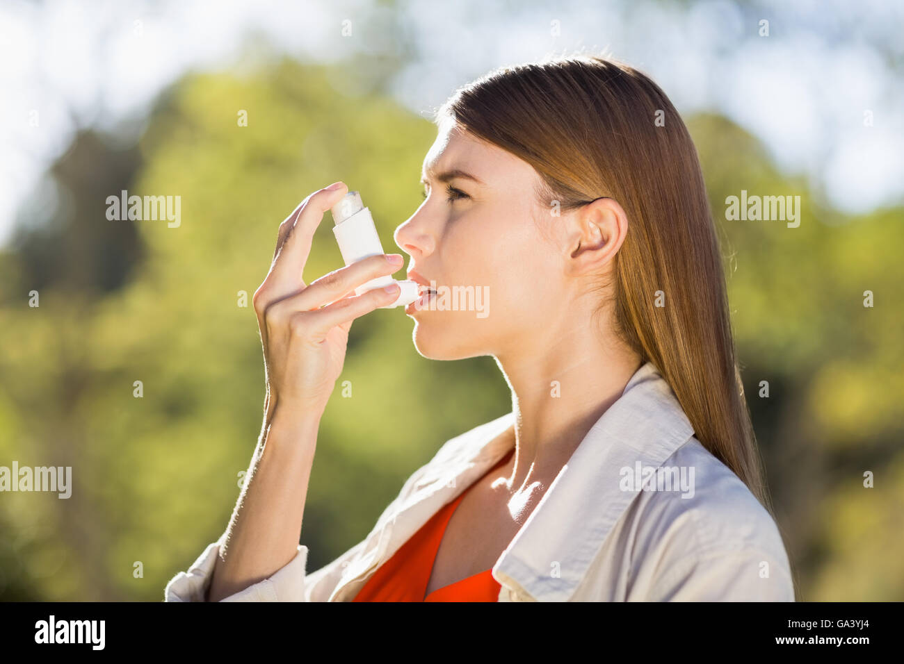 Donna che utilizza l'asma inalatore Foto Stock