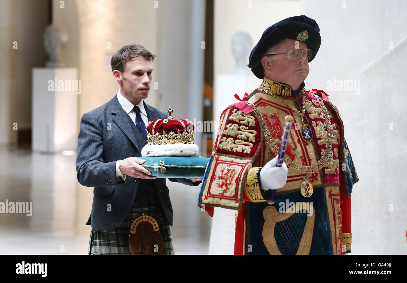 Il Duca di Hamilton e Brandon (sinistra) che porta la Corona Di Scozia attraverso il Giardino Lobby, davanti all'apertura della quinta sessione del Parlamento scozzese di Edimburgo. Foto Stock