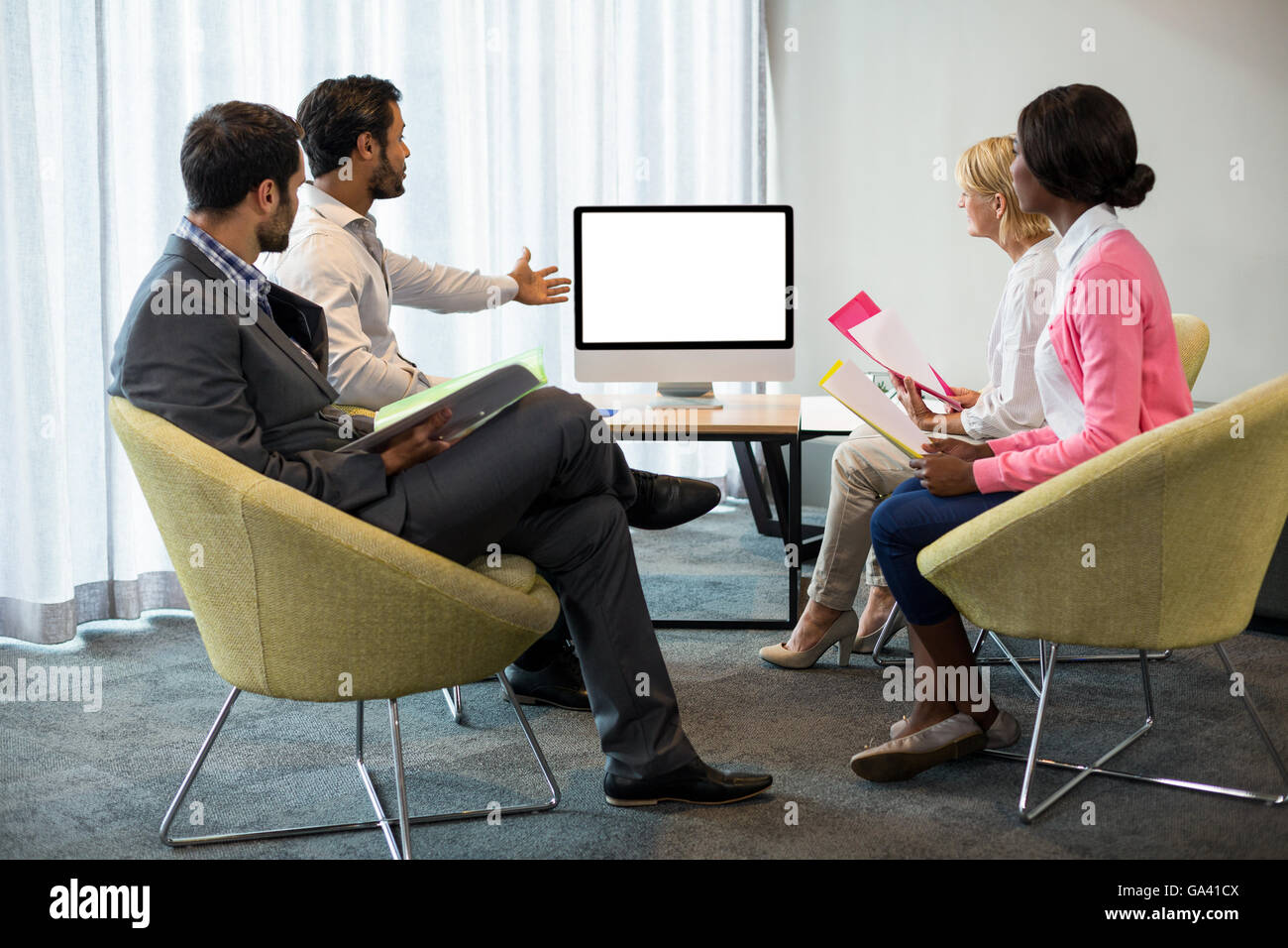 La gente di affari che guarda uno schermo durante una conferenza video Foto Stock