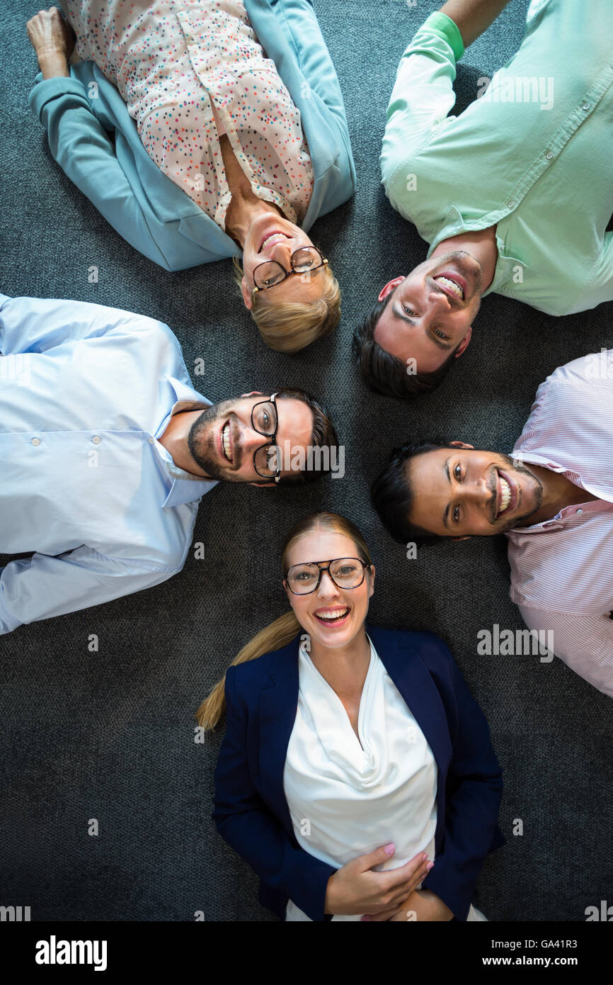 Il team di Business sdraiato sul pavimento con testa insieme Foto Stock