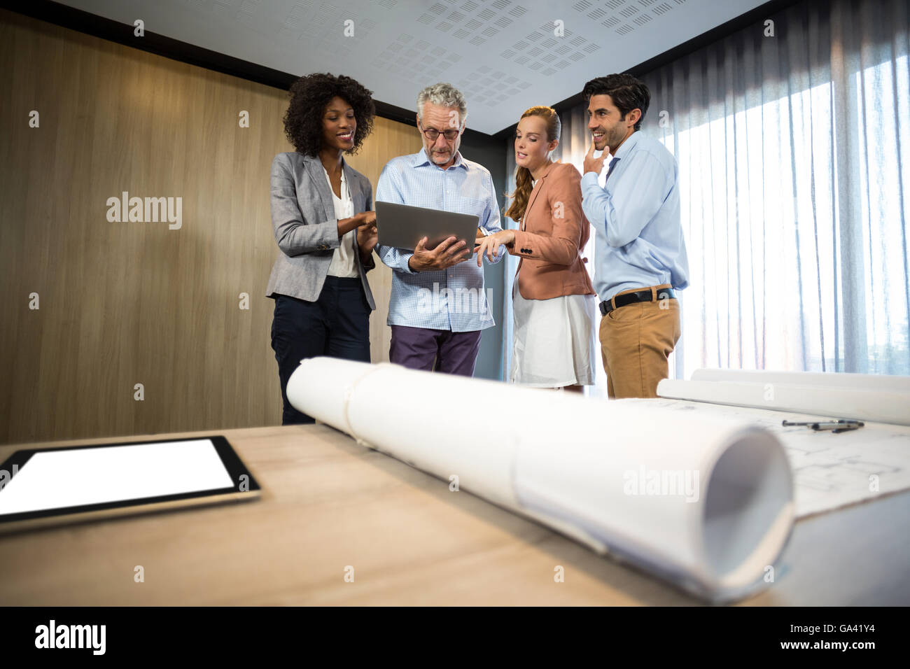 La gente di affari discutendo su computer portatile in ufficio Foto Stock