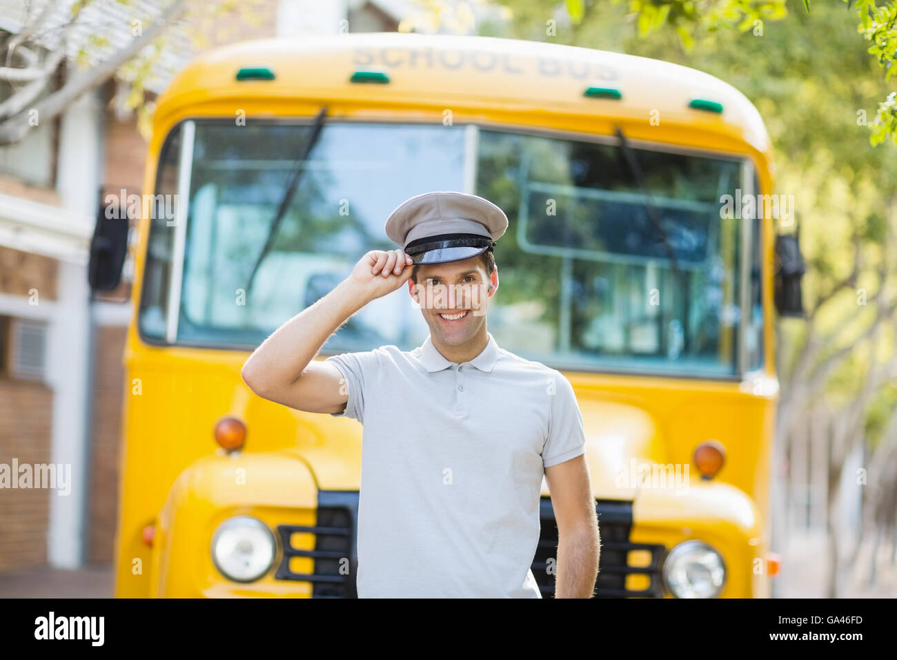 Bus driver sorridente nella parte anteriore del bus Foto Stock