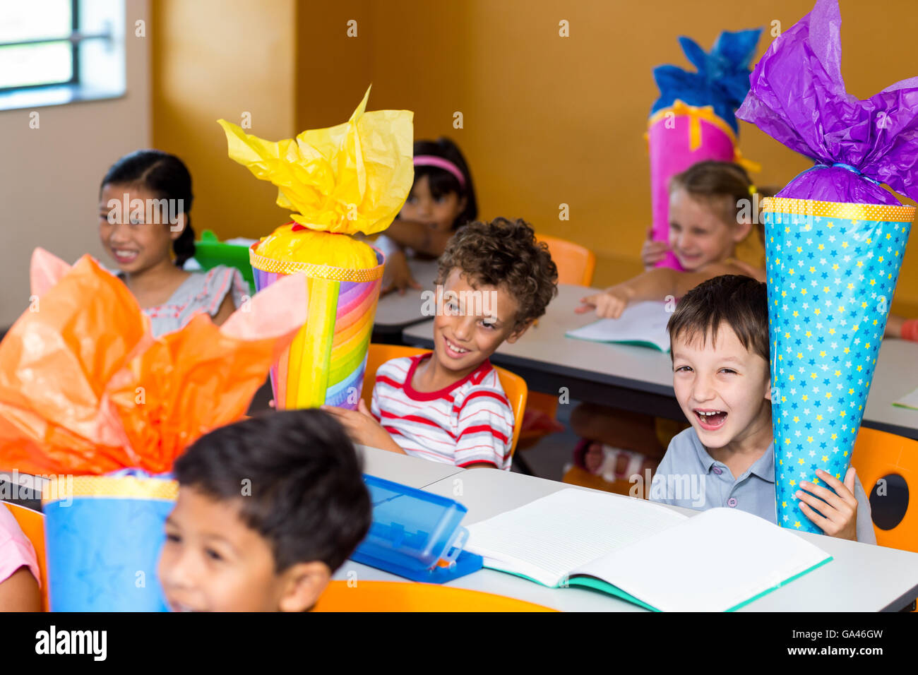 Allegro bambini con artigianato seduta sul banco di lavoro Foto Stock