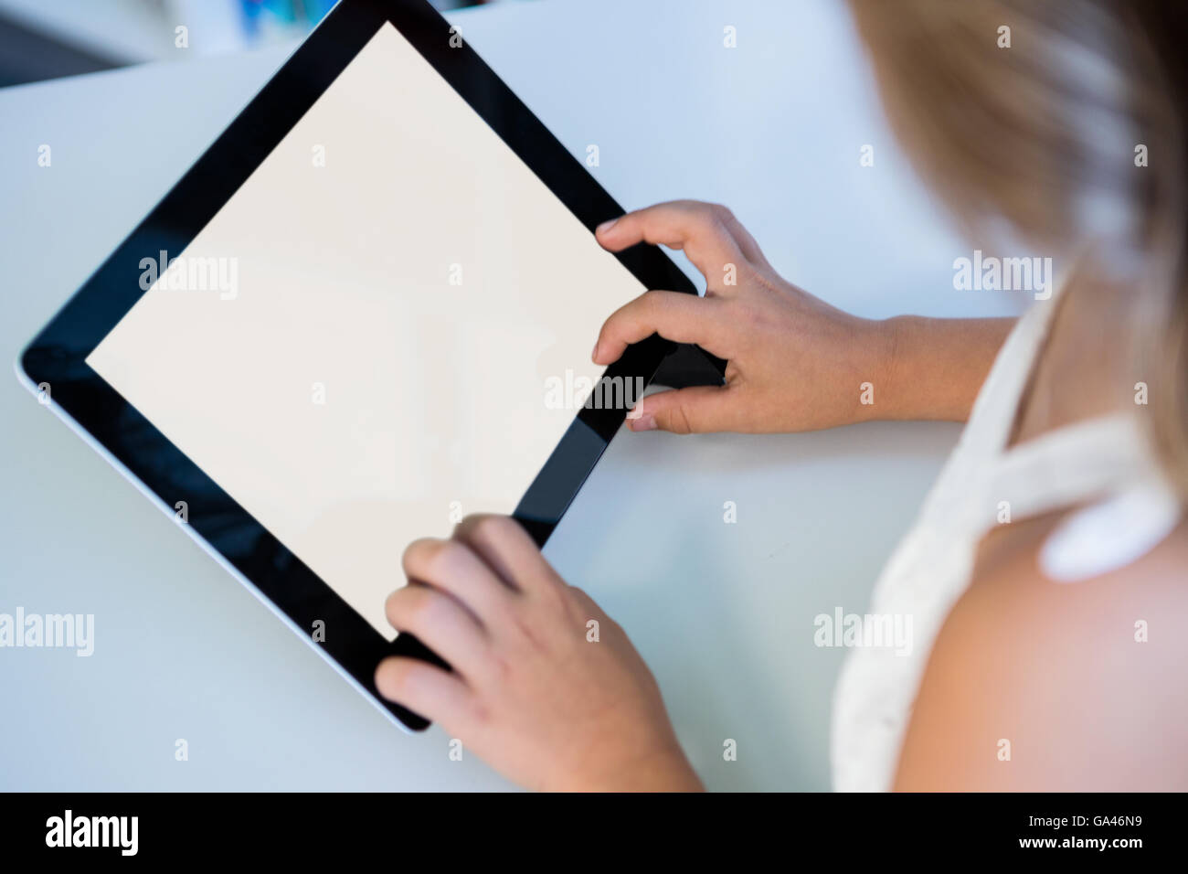 Immagine ritagliata della ragazza con tavoletta digitale in libreria Foto Stock