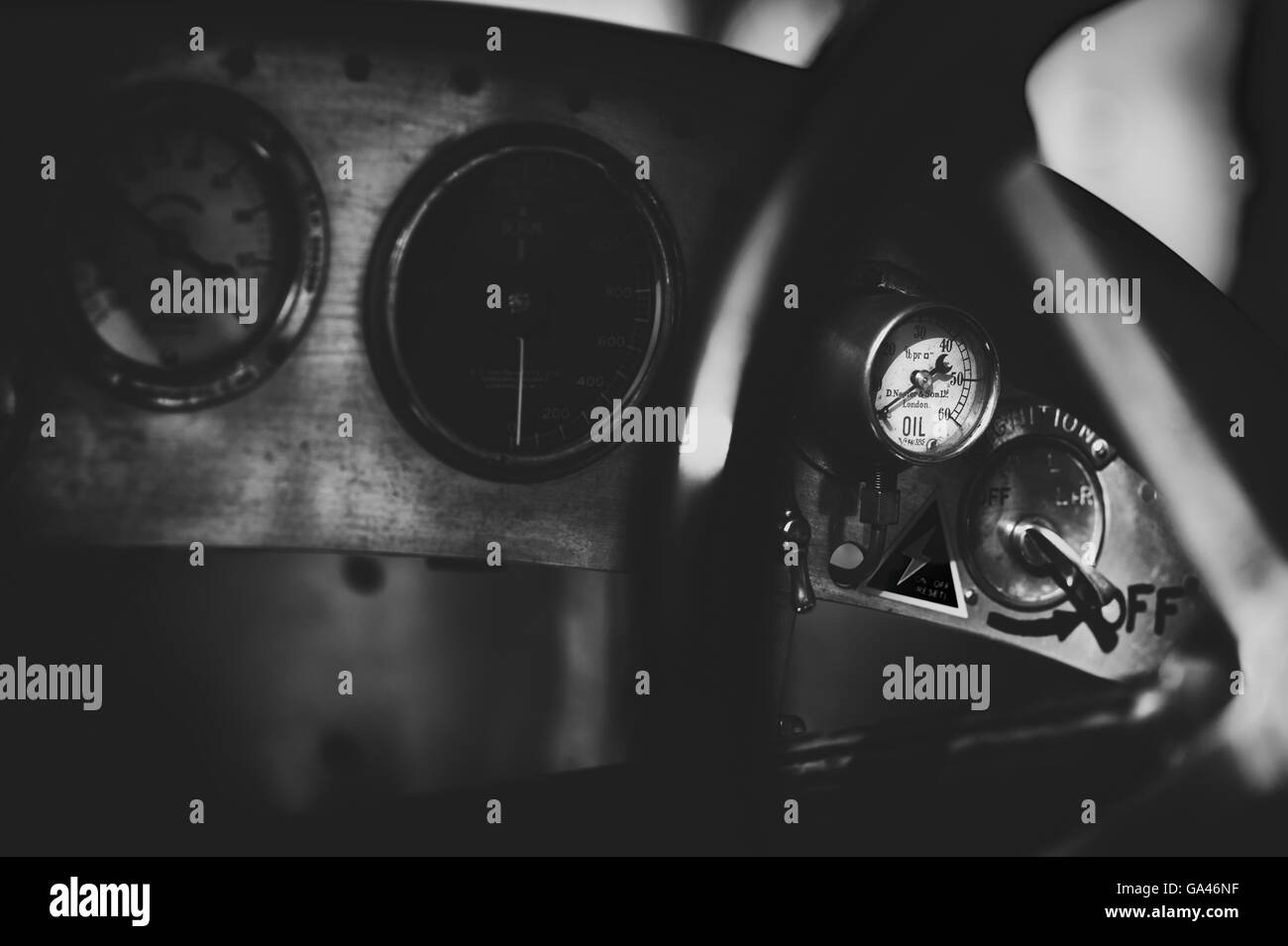Oli manometro illuminato dalla luce del sole su una Bugatti vintage racing cruscotto di automobile. Monocromatico Vintage filtro applicato Foto Stock