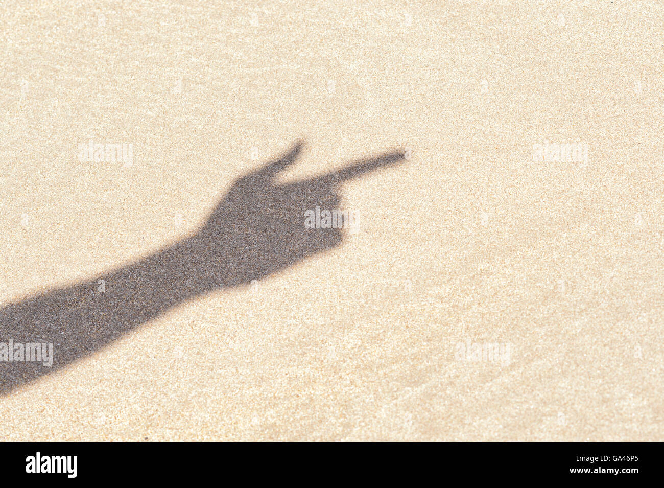 Ombra di un dito puntato su di una spiaggia di sabbia. Regno Unito Foto Stock