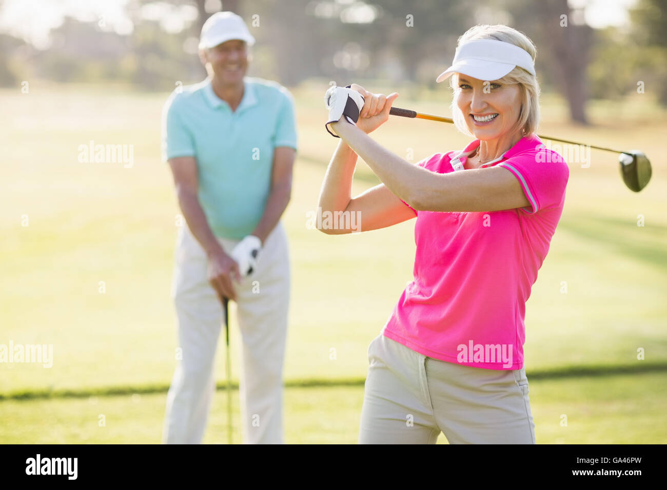 Ritratto di fiducioso donna matura portante golf club da uomo Foto Stock