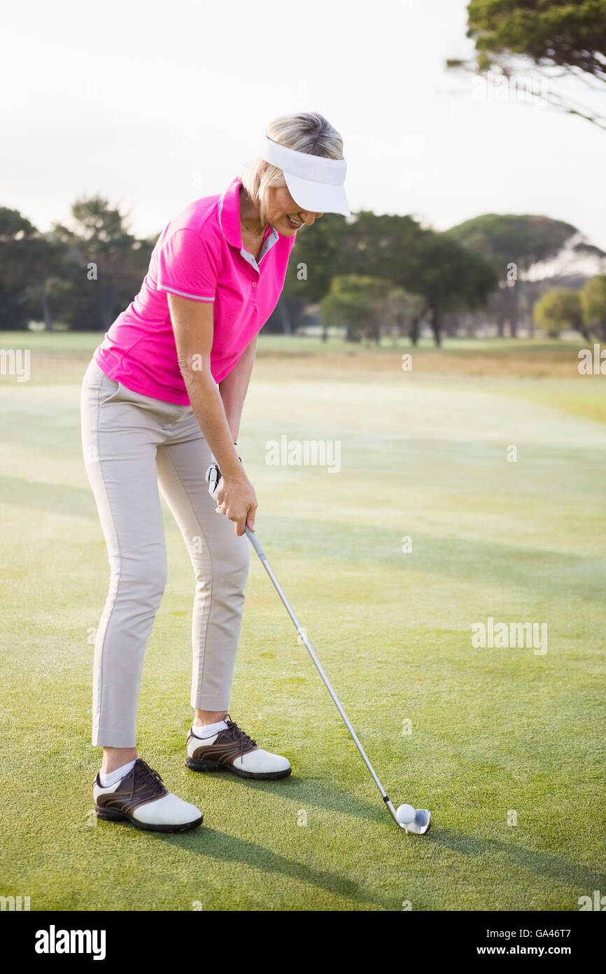 Donna golfista prepara il suo colpo Foto Stock