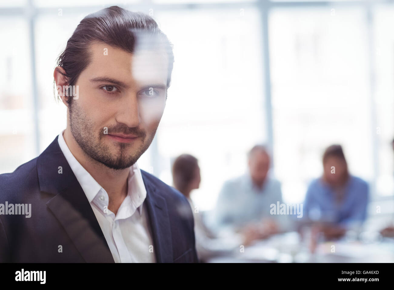 Imprenditore in ufficio visto attraverso il vetro Foto Stock