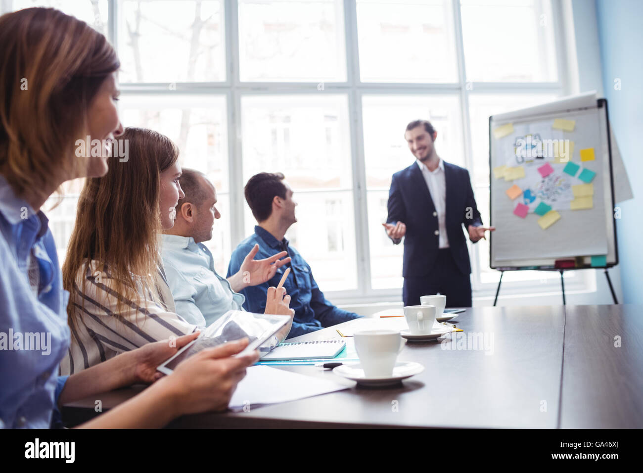 Imprenditore dando la presentazione di fronte a colleghi Foto Stock