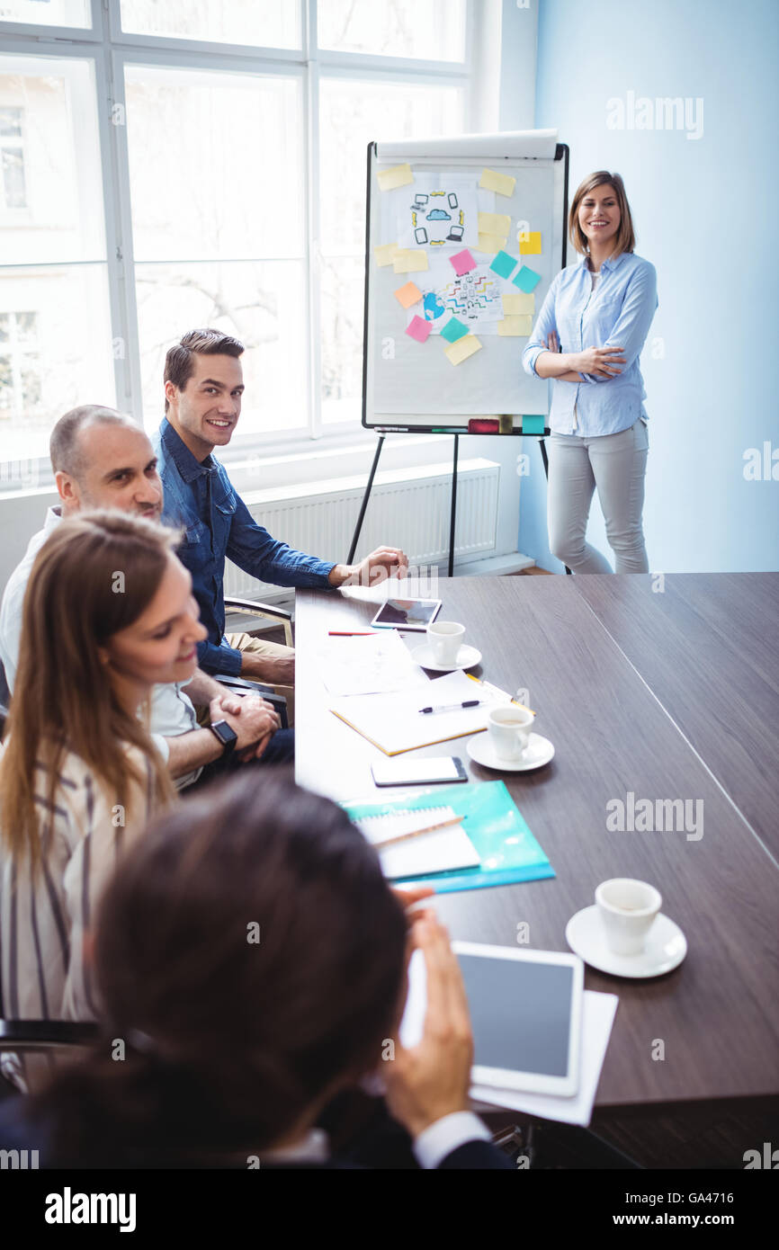 Imprenditrice sorridente con i colleghi di lavoro nella sala riunioni Foto Stock