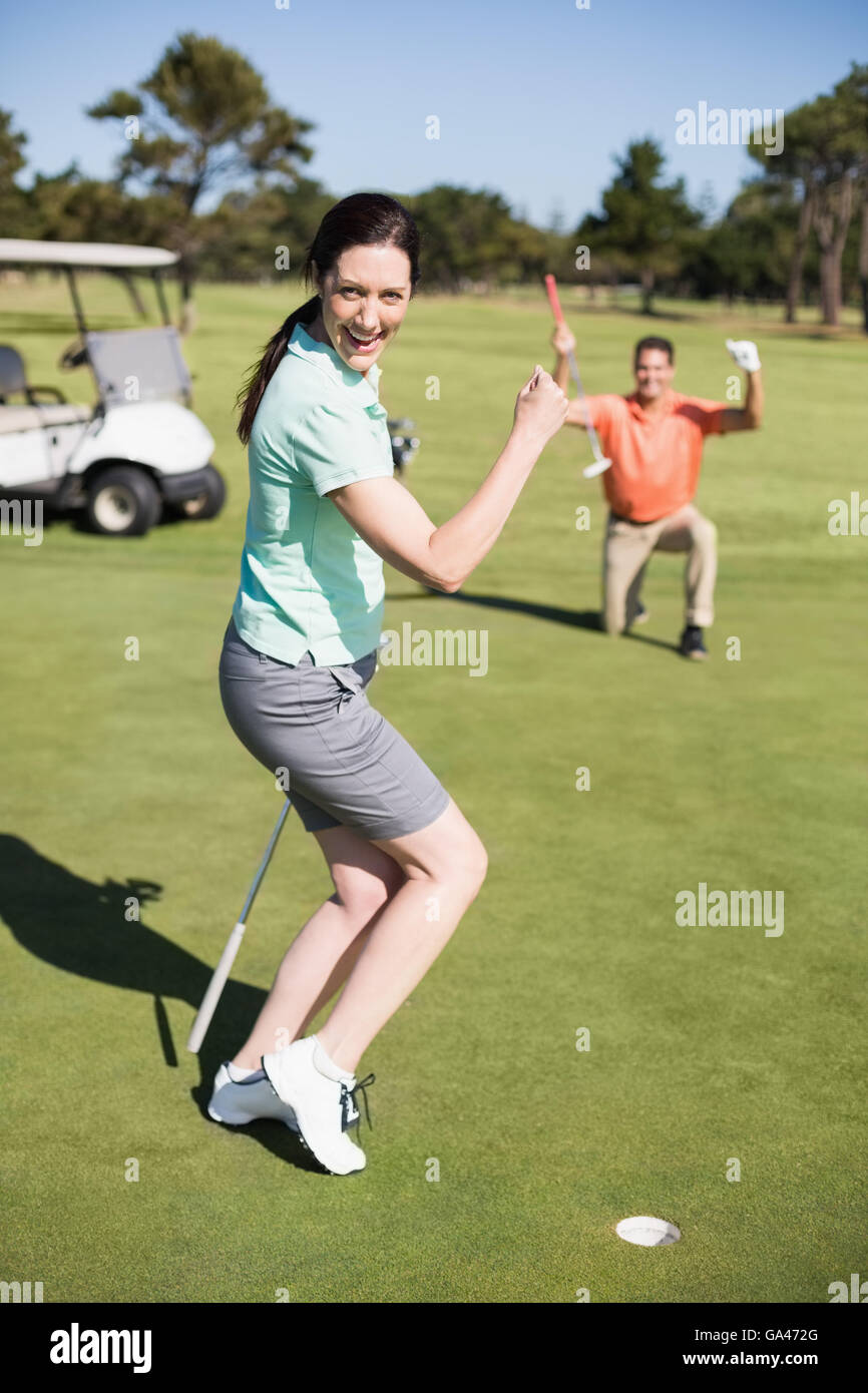 Ritratto di felice golfista donna clenching pugno Foto Stock