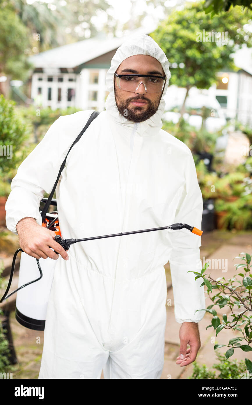 Ritratto di uno scienziato maschio la spruzzatura di pesticidi Foto Stock