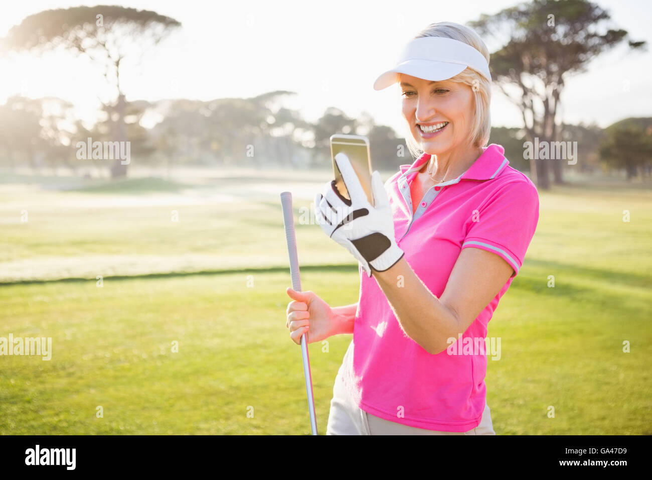 Donna golfista cercando il suo telefono cellulare Foto Stock