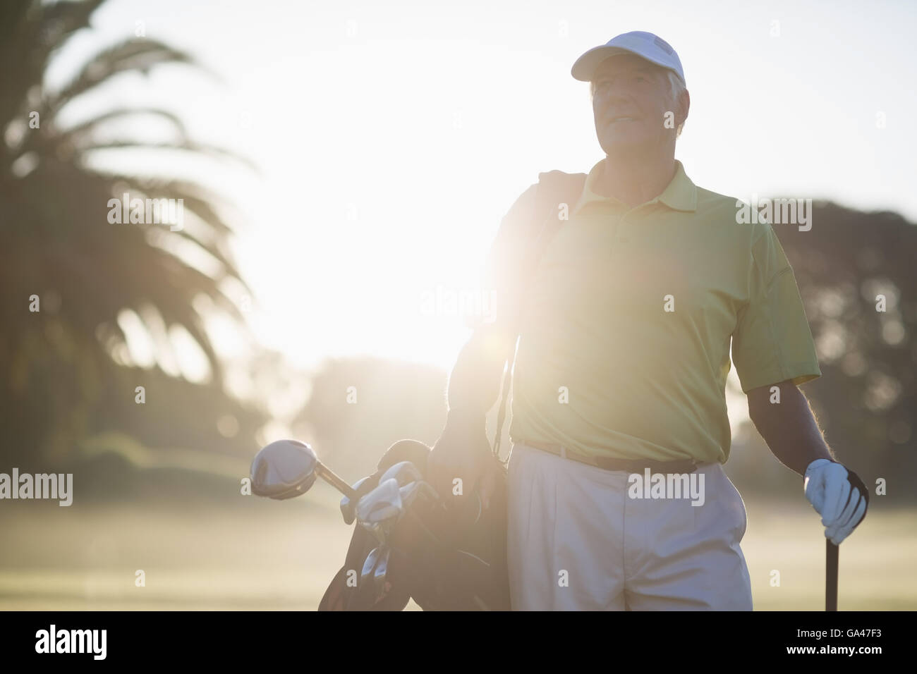 Uomo maturo che trasportano borsa da golf Foto Stock