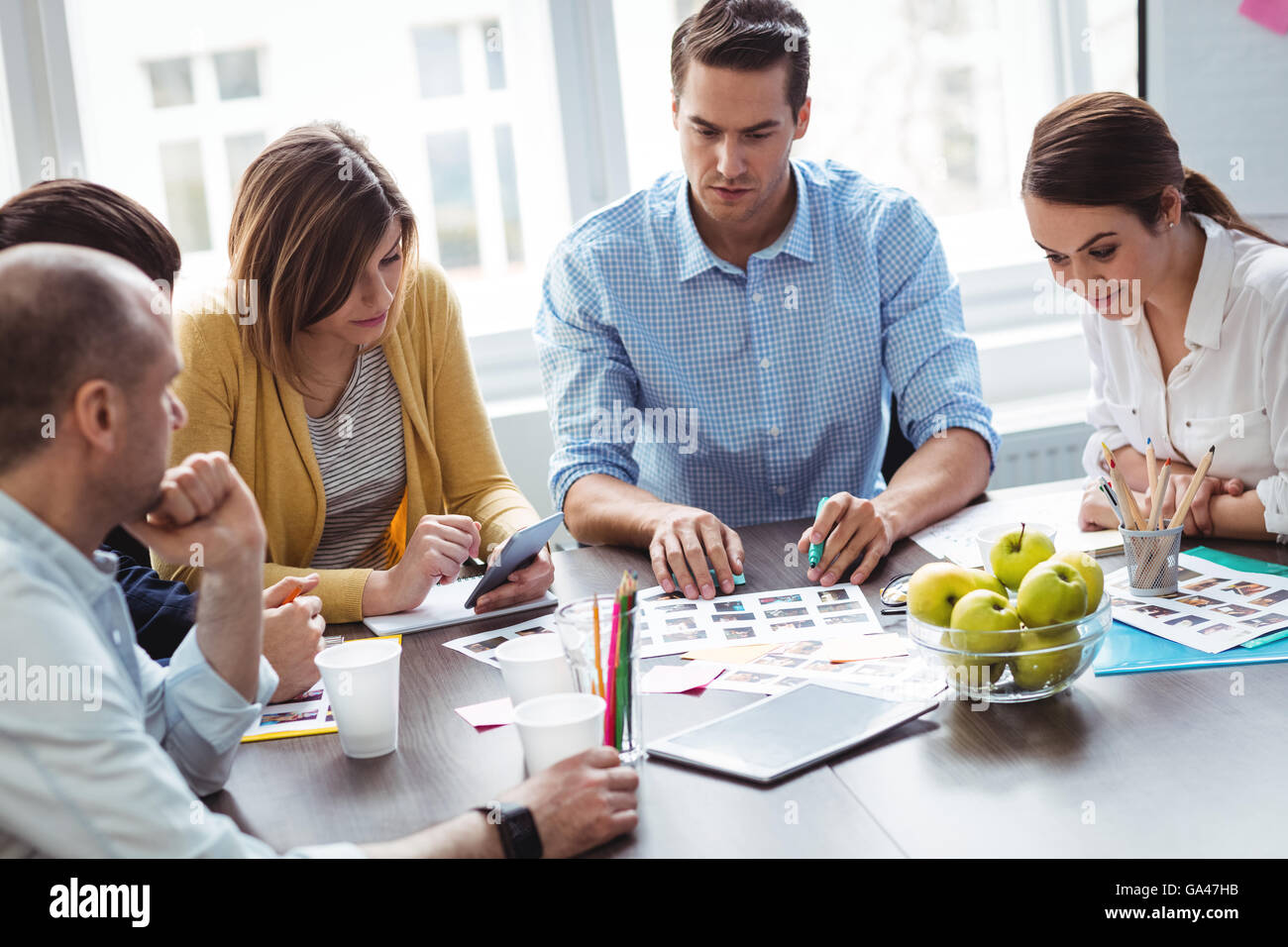 I redattori con documenti di lavoro in sala riunioni Foto Stock