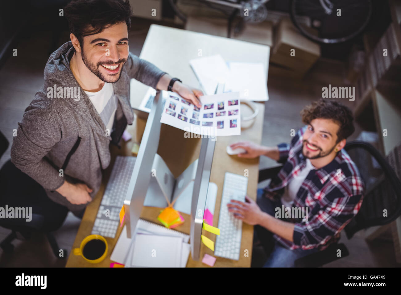 Ritratto di happy photo gli editori che lavorano al computer desk Foto Stock