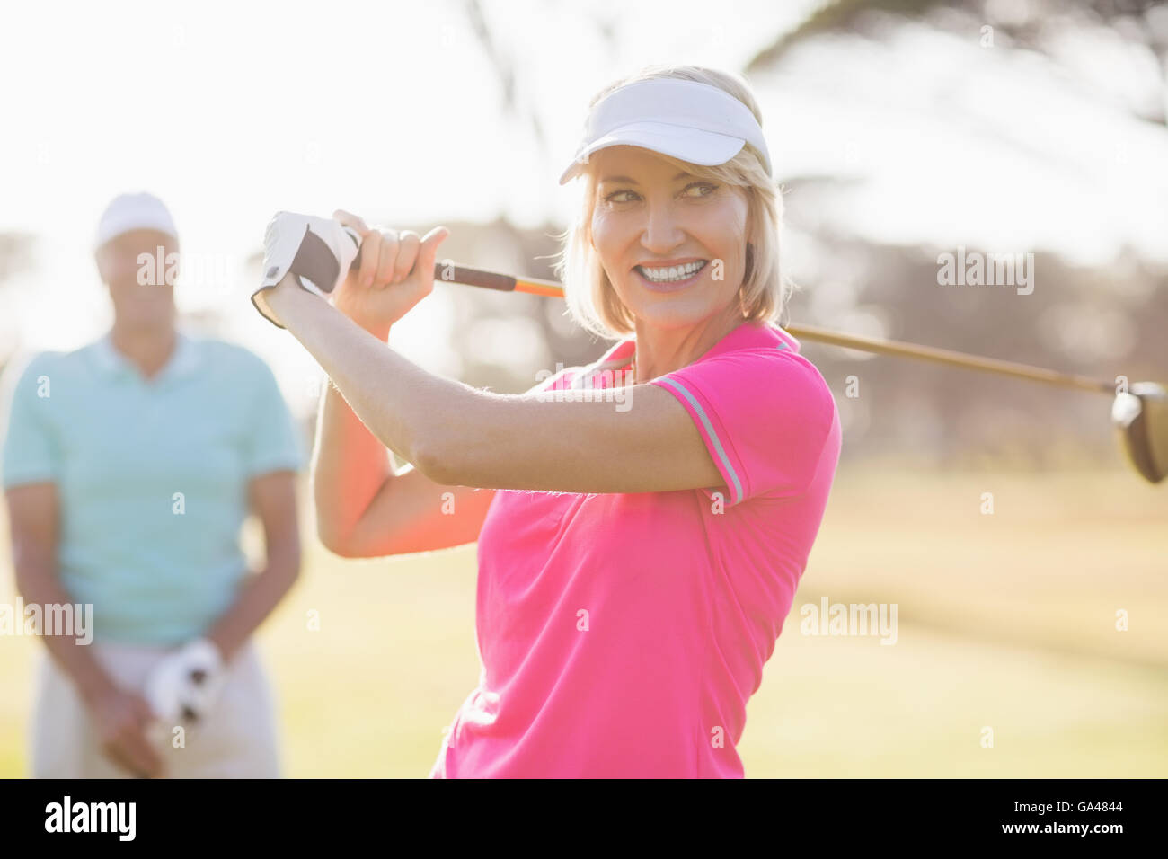 Fiducioso donna matura portante golf club da uomo Foto Stock