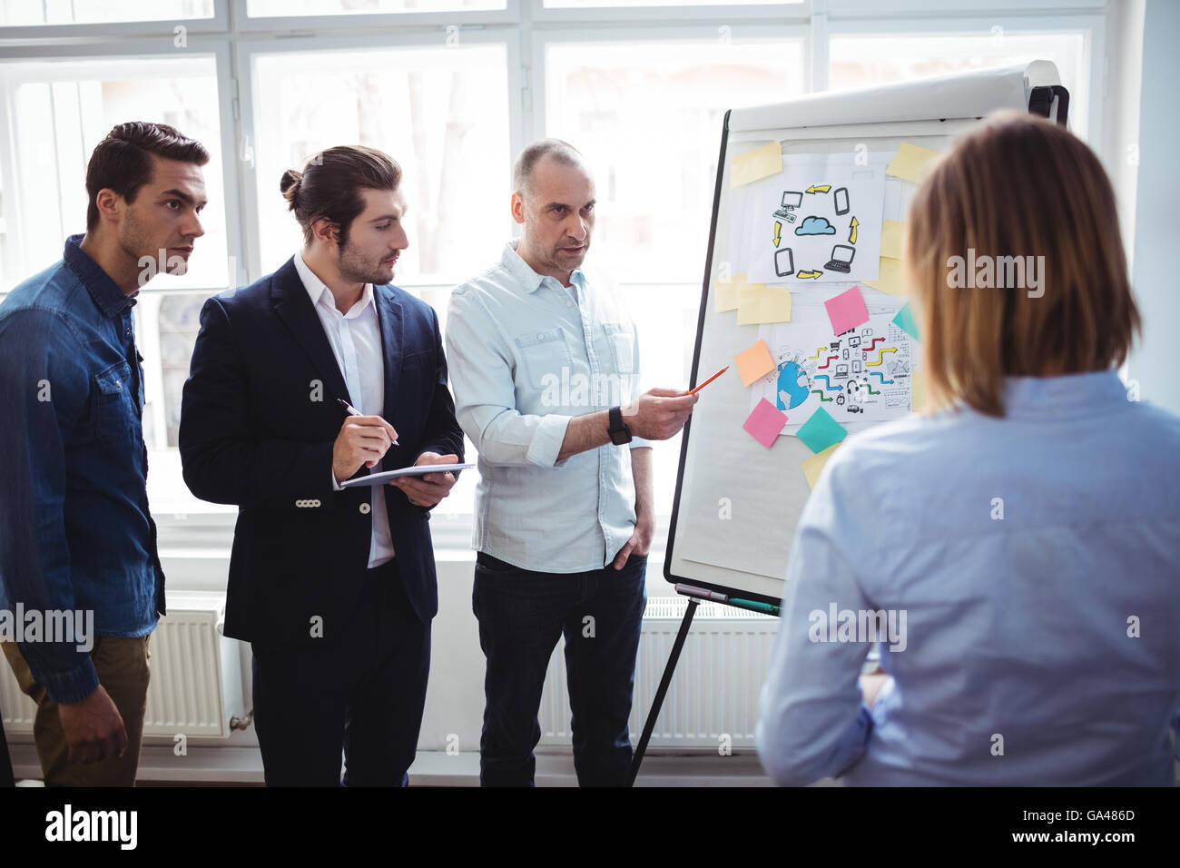 Imprenditore con i colleghi per discutere in sala riunioni Foto Stock