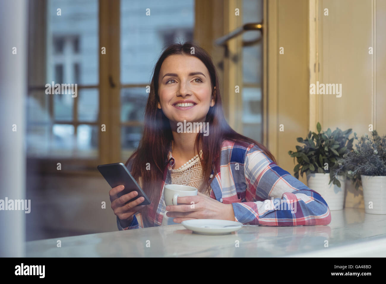 Felice bella donna con il cellulare al cafe Foto Stock