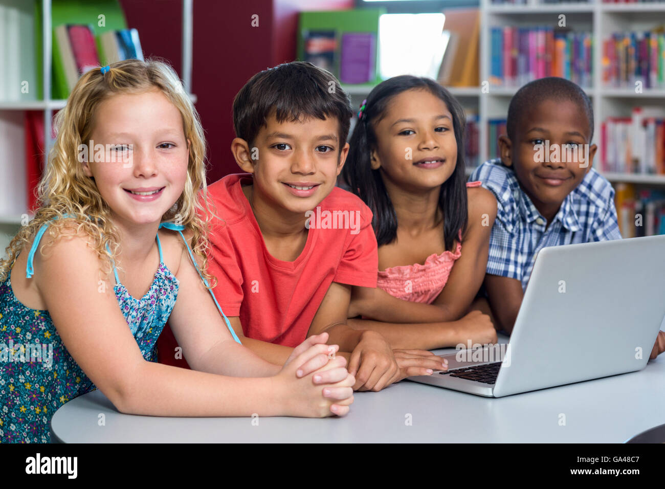 Felici i compagni di scuola con il computer portatile Foto Stock