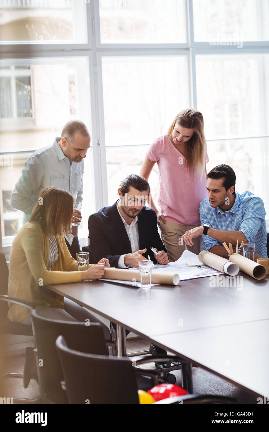 La gente di affari con blueprint in sala riunioni Foto Stock