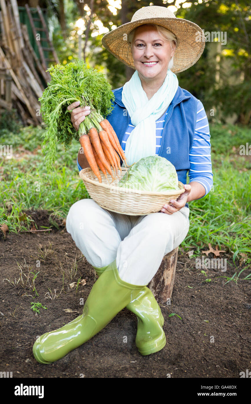 Ritratto di donna felice con le carote in giardino Foto Stock