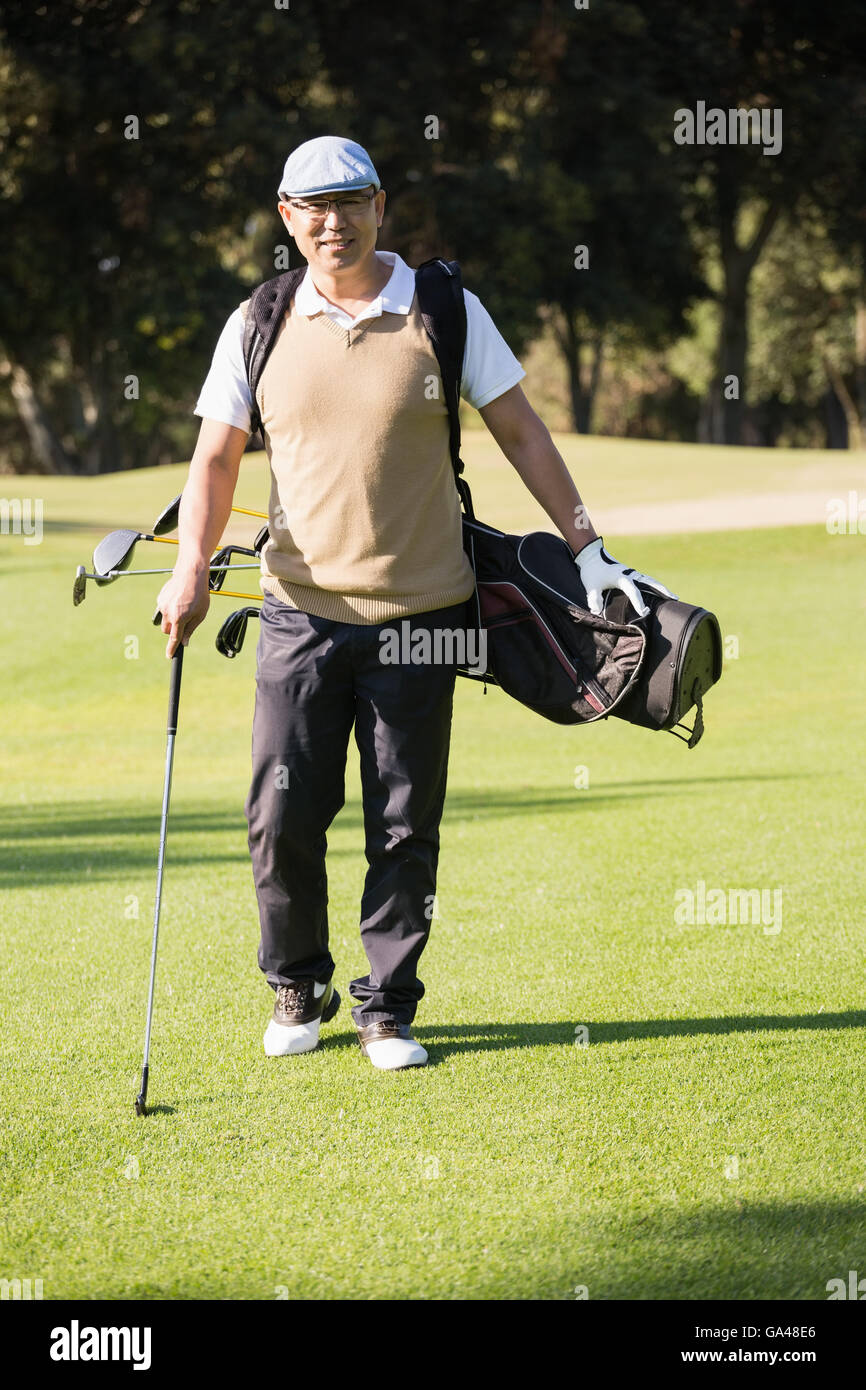 Sportivo in posa con la sua sacca da golf Foto Stock